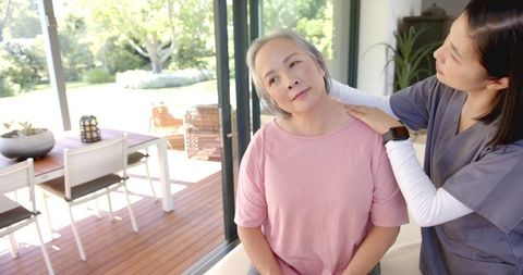 Physiotherapist Provides Shoulder Massage to Senior Woman at Home