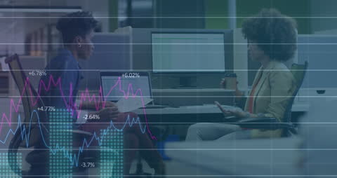 Businesswomen Analyzing Financial Data at Workstation
