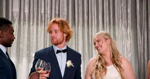 Happy Couple Toasting with Friends at Cozy Wedding Reception