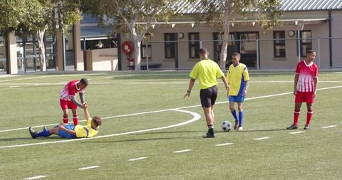 Soccer players with referee on field learning sportsmanship