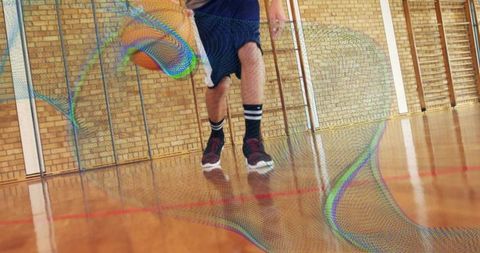 Teen basketball player dribbling with athletic motions