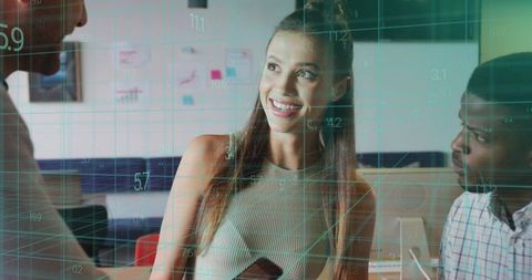 Smiling intern discussing data overlays with team in open-plan office, digital analytics