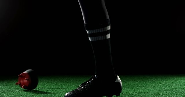 Soccer player wearing black socks and cleats in motion, focused on ball and lower body. Perfect for sports advertisements, soccer training guides, athlete-related promotions, and dynamic action scenes to illustrate movement and energy in sports.