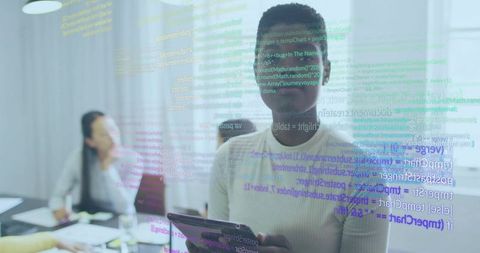 Black woman presenting with tablet in glass boardroom displaying floating code overlay