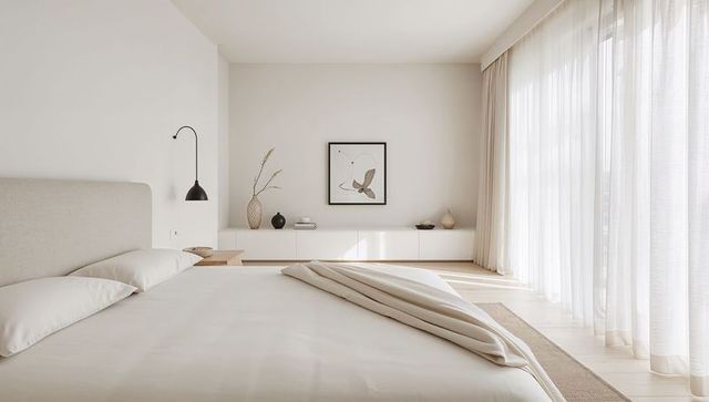 Minimalist bedroom interior with upholstered bed and natural light