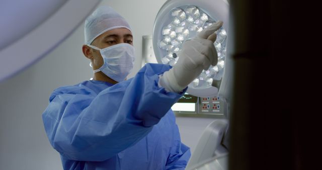 Surgeon Prepares Operating Room with Sterile Equipment Under LED Surgical Light - Download Free Stock Images Pikwizard.com