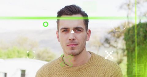 Young man wearing tan knitted sweater showing neon hud overlay on outdoor portrait