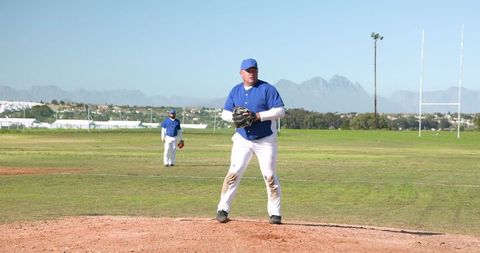 Pitcher in Blue Uniform Throwing Baseball on Sunny Field