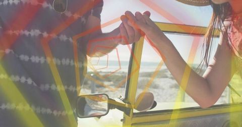 Couple holding hands through yellow van door, leaning toward sunlit beach at golden hour