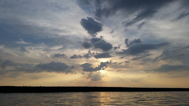 Dramatic Clouds Over Sunset at Horizon on Calm Water - Download Free Stock Photos Pikwizard.com