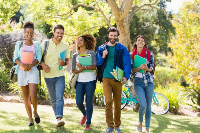 This image shows a diverse group of college students walking together on a sunny day on campus. They are carrying books and wearing casual clothing, indicating a relaxed and friendly atmosphere. This image can be used for educational websites, university brochures, promotional materials for student activities, or articles about college life and diversity.