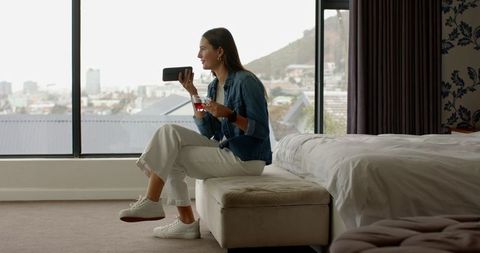 Woman Relaxing in Hotel Room Talking on Phone with Coffee