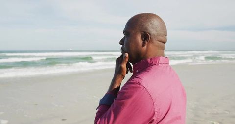 Man Contemplating on Beach with Rolling Waves