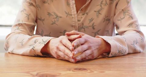 Confident Business Professional Clasping Hands at Table