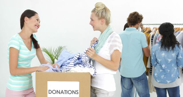 Team of people going through donation box of clothes in their workplace