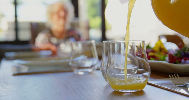 Serving Fresh Juice at a Sunlit Breakfast Table with Blurred Background - Download Free Stock Images Pikwizard.com