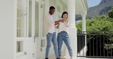Multicultural couple embracing on scenic balcony