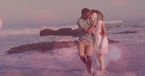 Romantic Couple Strolling on Ocean Shore at Sunset