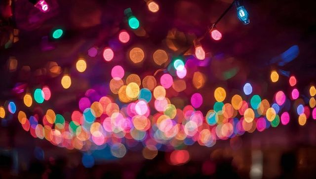 Colorful bokeh string lights creating festive ambient glow with in-focus bulb and wires