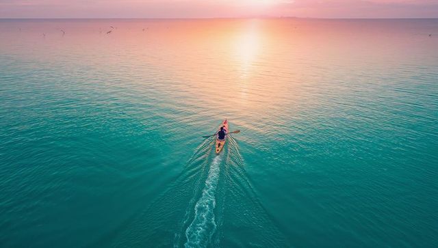Kayaker Paddling During Stunning Ocean Sunset Adventure