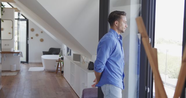 Man Reflecting by Window in Modern Living Space - Download Free Stock Images Pikwizard.com