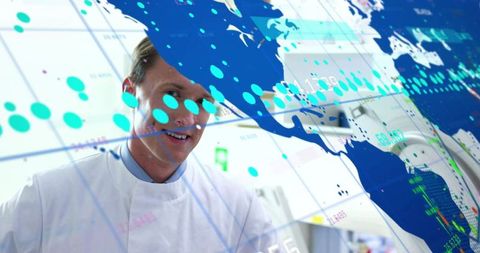 Scientist studying geospatial data visualization with world map overlay in research lab