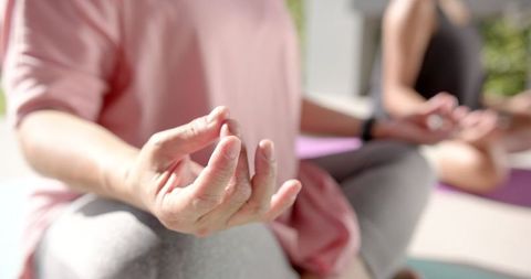 Elderly Woman Meditating with Family in Relaxing Environment