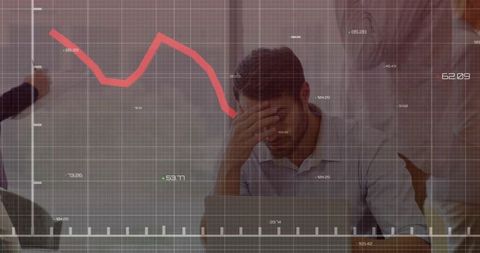 Businessman holding head at meeting with downward market graph overlay conveying stress
