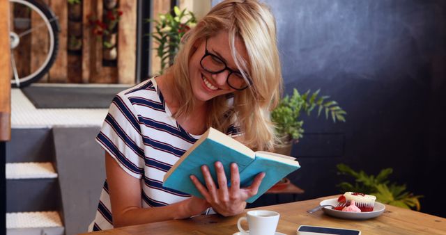 Smiling Blonde Woman Reading Book at Cozy Cafe - Download Free Stock Images Pikwizard.com