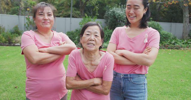 Three Generations of Women Smiling in Pink Shirts and Folding Arms - Download Free Stock Photos Pikwizard.com