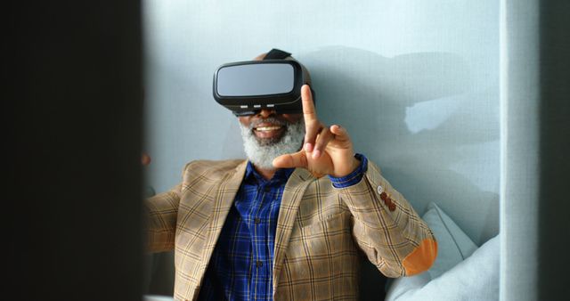 Elderly man wearing VR headset, joyfully interacting with virtual reality. Perfect for use in technology advertisements, VR usage presentations, elderly engagement marketing, showcasing senior citizen's interaction with modern technology, or portraying joy in innovative experiences.