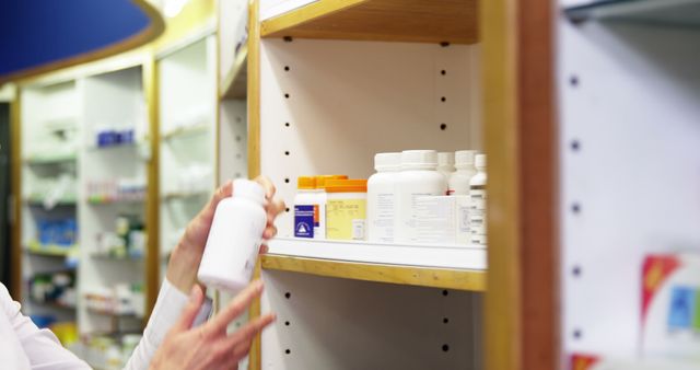 Pharmacist checking a bottle of drug in pharmacy