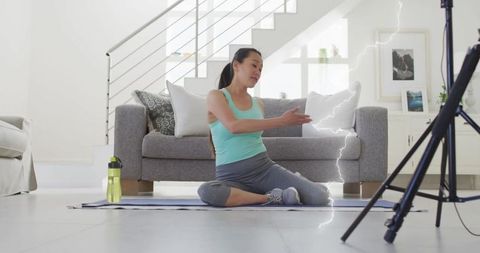 Woman Stretching and Filming Fitness Routine at Home