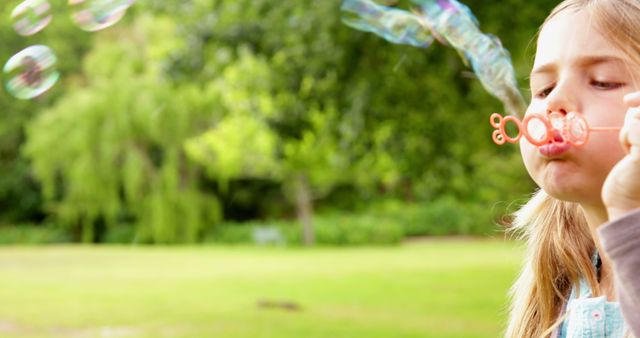 Cute little girl blowing bubbles in park on a sunny day - Download Free Stock Photos Pikwizard.com