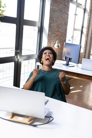 Excited Woman Celebrating Success in Modern Office
