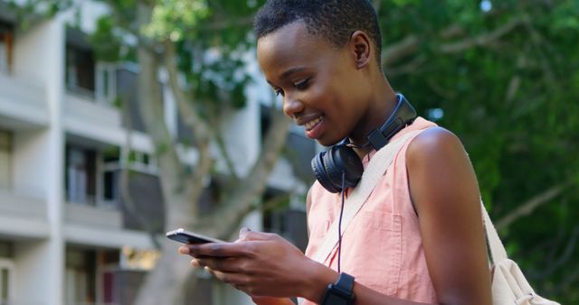 Young African Woman Smiling and Using Smartphone Outdoors - Download Free Stock Images Pikwizard.com