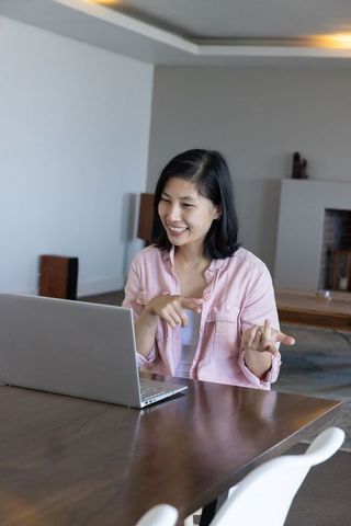 Asian Woman Engaging in Video Call from Stylish Home Office