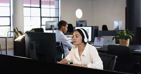Focused Professionals Analyzing Data on Computers in Modern Office