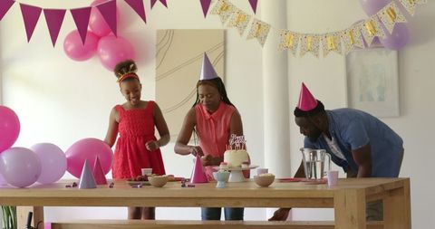 Family celebrating birthday joyfully with cake and decorations