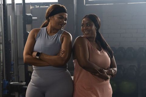 African american women standing and smiling in gym weights building strength and bonds