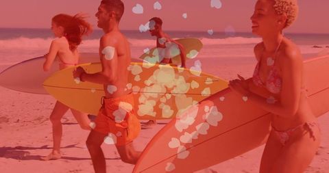 Youthful surfers joyfully carrying boards along beach at sundown