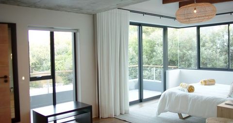 Bright Scandinavian Bedroom with White Linens, Rolled Yellow Towels and Balcony