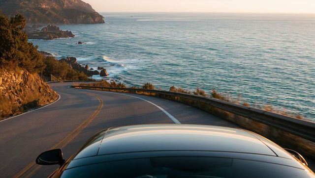 Driving coastal highway at golden hour with reflective car roof and ocean view