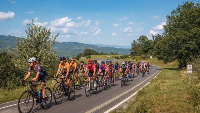 Cycling peloton riding through scenic rolling hills on sunny country road race training