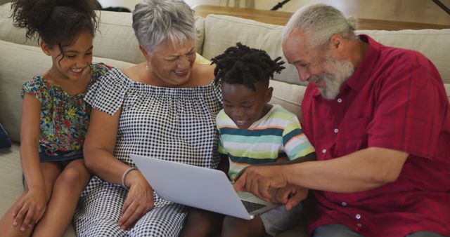 Grandparents with Grandchildren Using Laptop on Sofa at Home - Download Free Stock Images Pikwizard.com