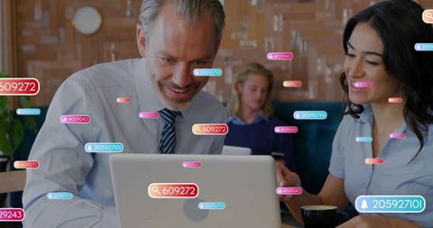 Collaborating over laptop in cafe with floating social media tags and coworking teamwork