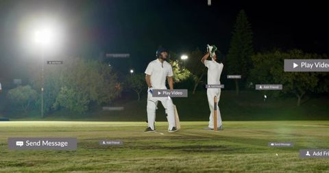 Two cricketers standing under floodlights wearing pads lifting helmet with social media overlays