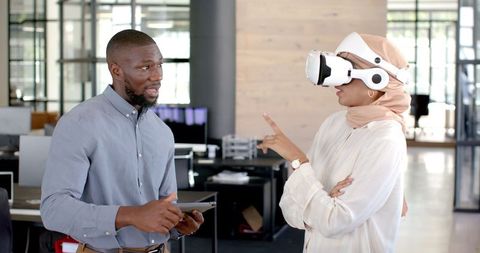 Colleagues Innovating with VR Headset in Office Meeting