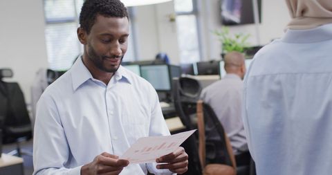 African American Businessman Analyzing Reports in Office