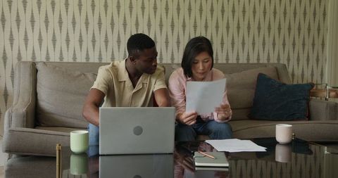 Diverse Team Collaborating on Documents in Modern Living Room